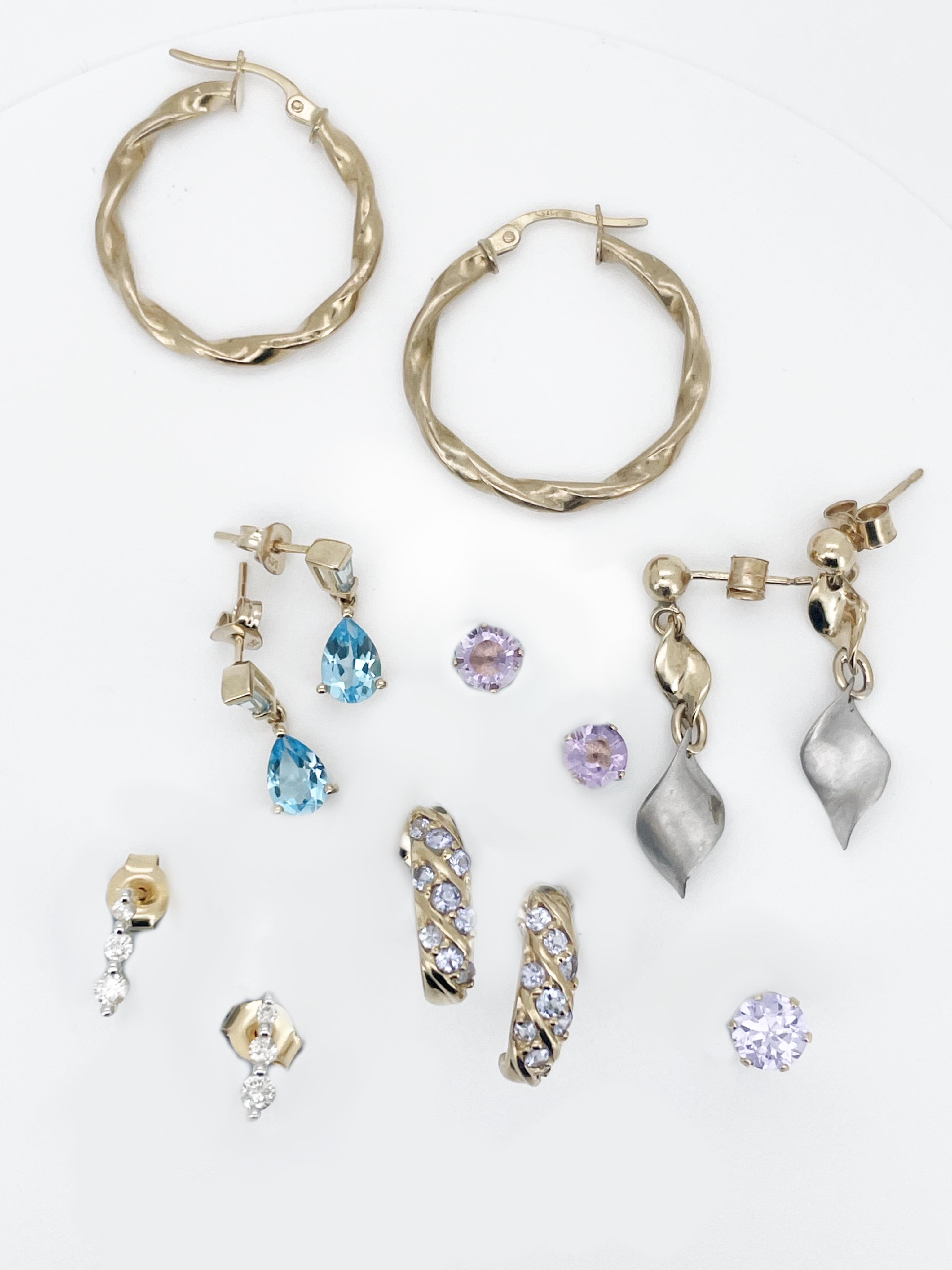 A pair of modern 750 yellow metal and graduated three stone diamond set ear studs, gross 1.1 grams, approx. 9mm, a pair of 9ct hoop earrings, a pair of two colour 9ct earrings, two pairs of 9ct and gem set earrings, gros